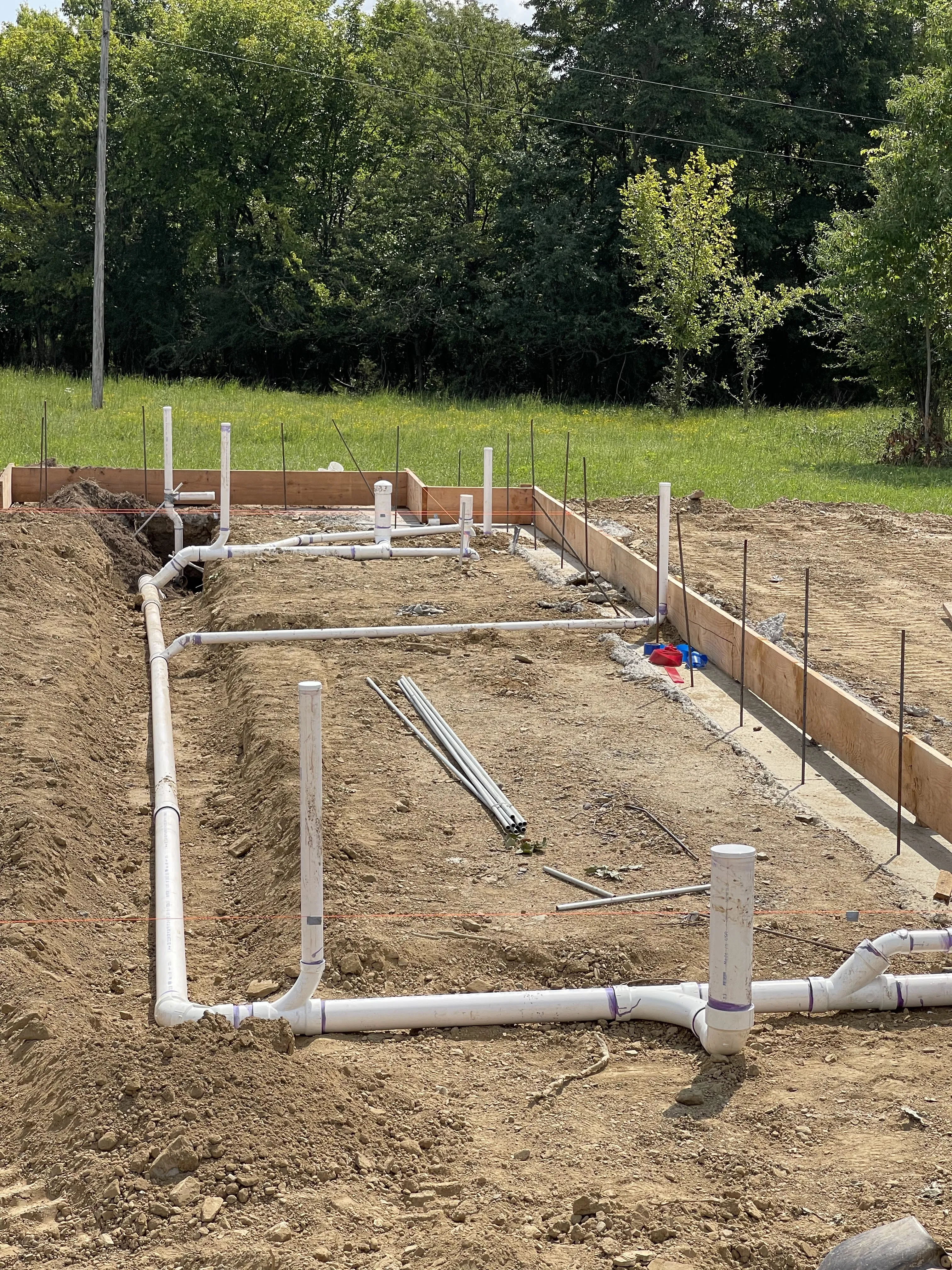PVC drain and vent lines laid out in a new home foundation before the slab pour