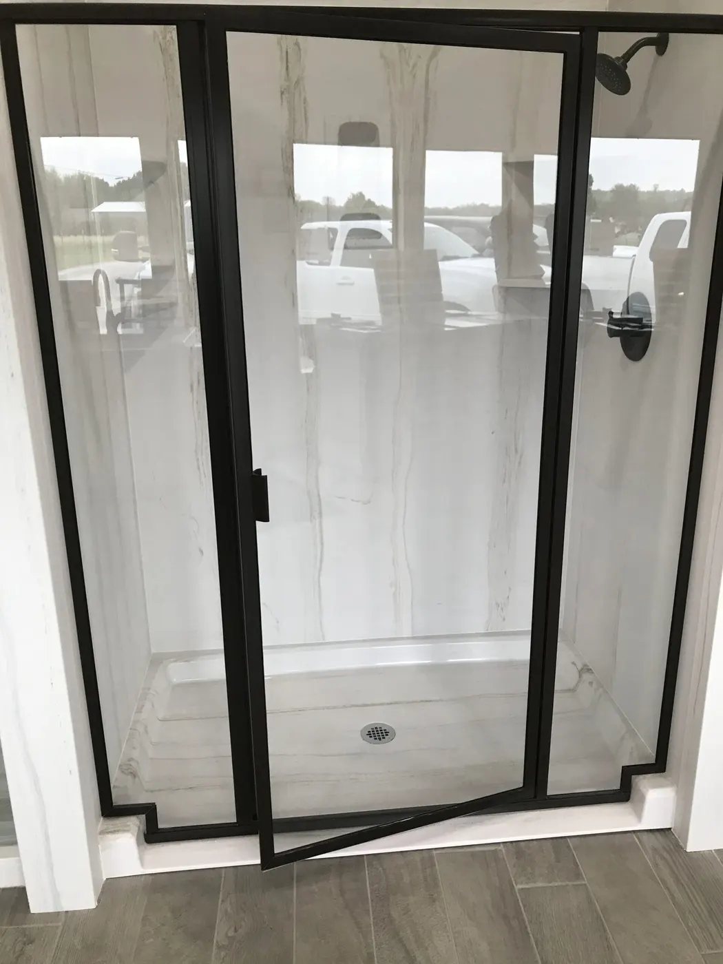 A new walk-in shower with a sliding glass door and tile floor